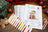Cross stitch kit with color chart and Christmas-themed decorations on a wooden surface