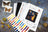 Cross stitch kit with butterfly design, threads, and tools on a textured surface.