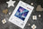 Cross stitch kit packaging with a polar bear design on a textured surface with decorative items.