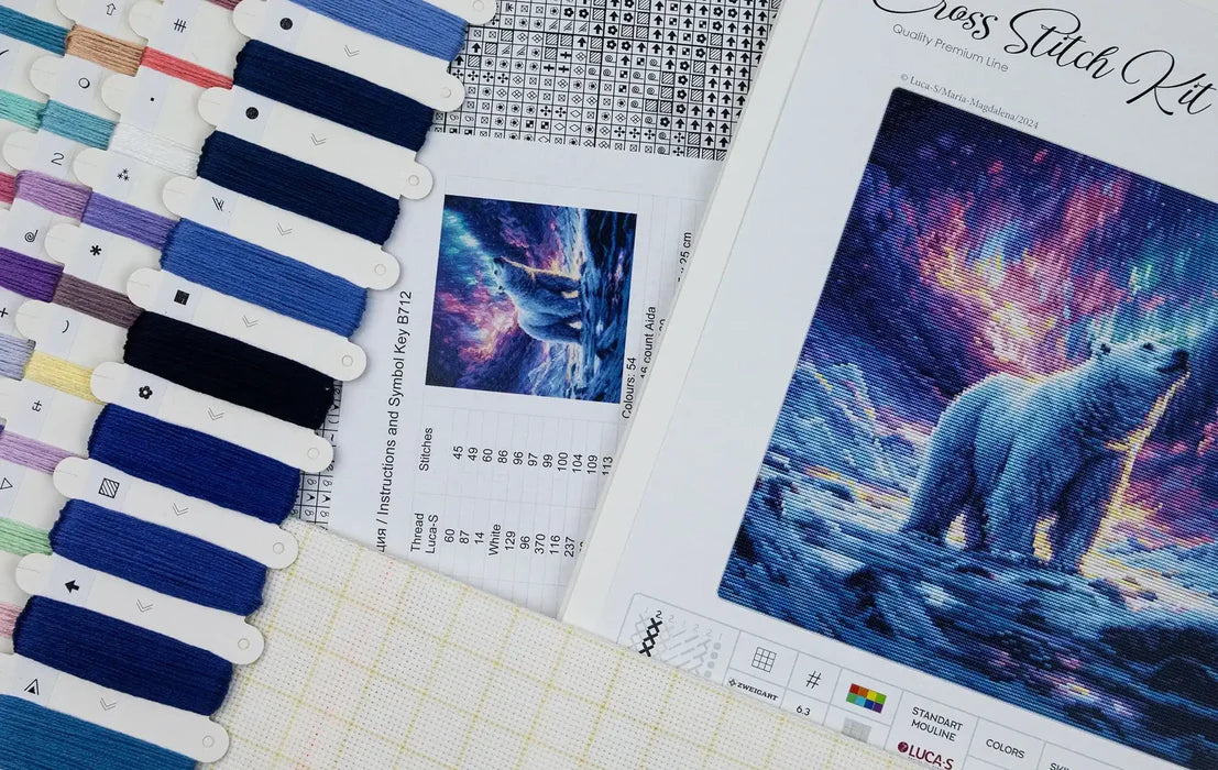 Cross stitch kit with pattern and color swatch on a textured surface