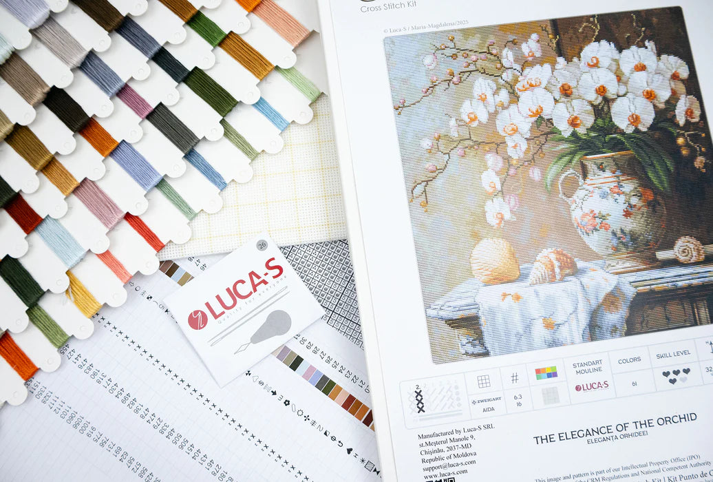 Color swatches and a painting of white flowers in a vase on a table.
