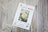 Lucas cross stitch kit packaging on a wooden surface with floral design
