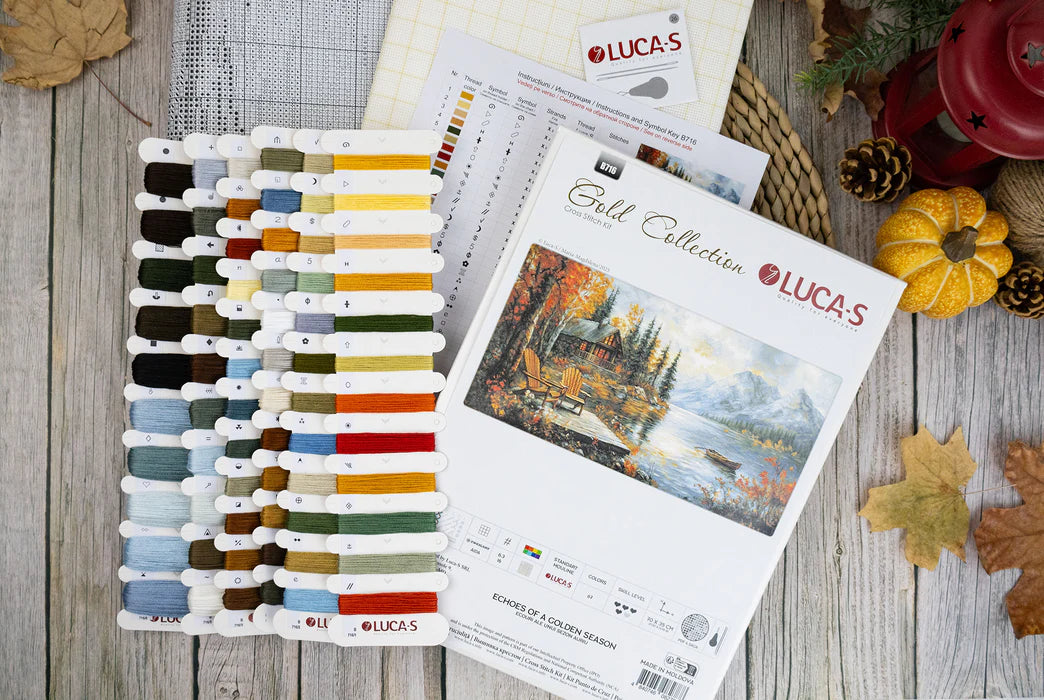 Lucas embroidery thread color chart and design book on a wooden surface with fall decorations.