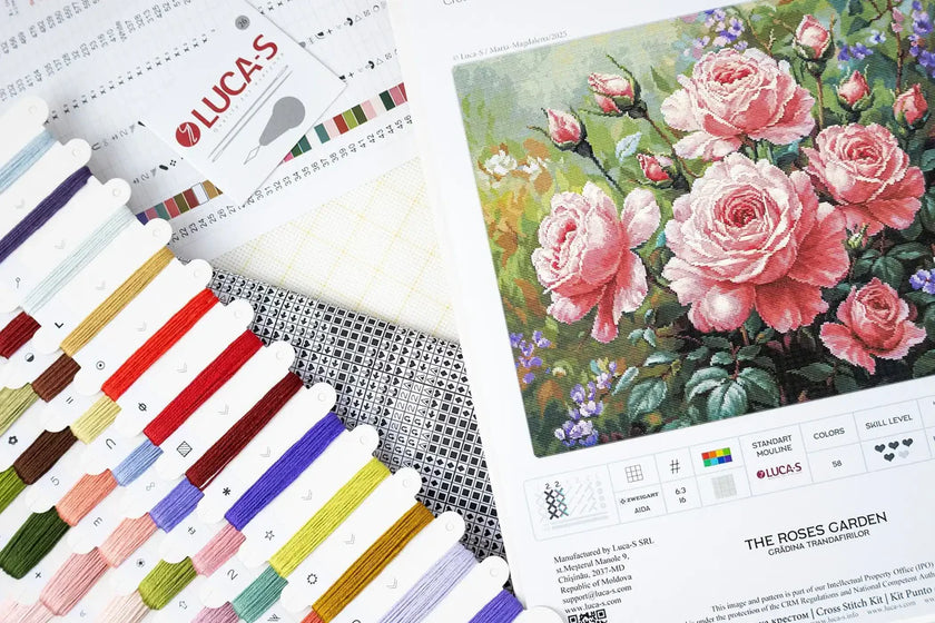 Color swatches, embroidery floss, and a painting of roses on a white background