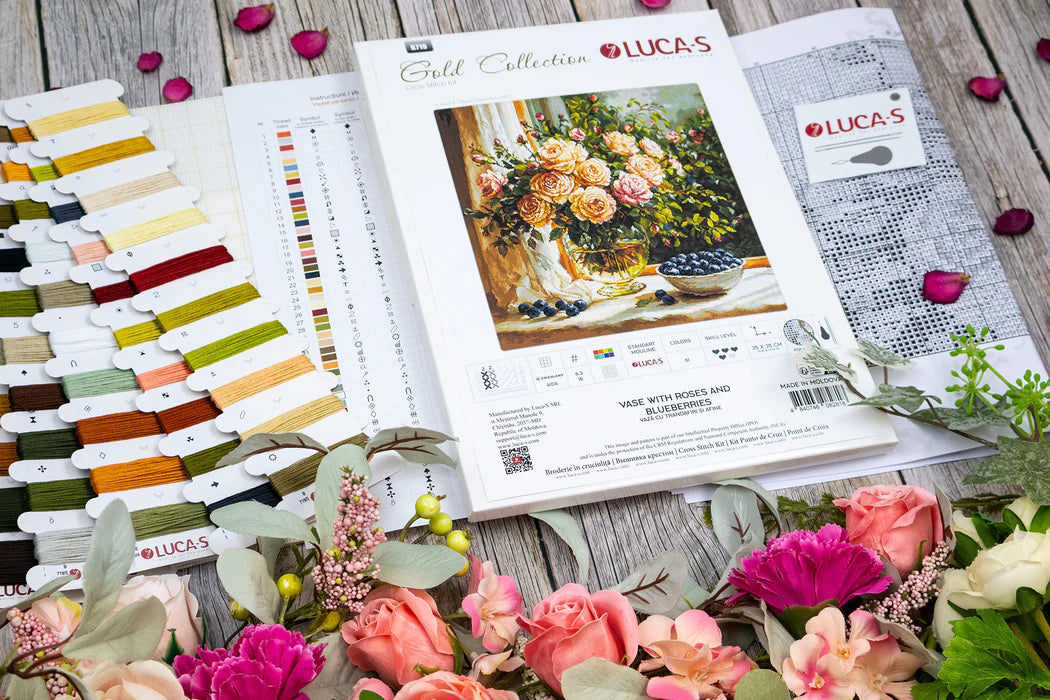 Lucas embroidery kit with color chart and floral arrangement on a wooden surface