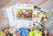 Cross-stitch kit with floral design and color swatch on a marble surface
