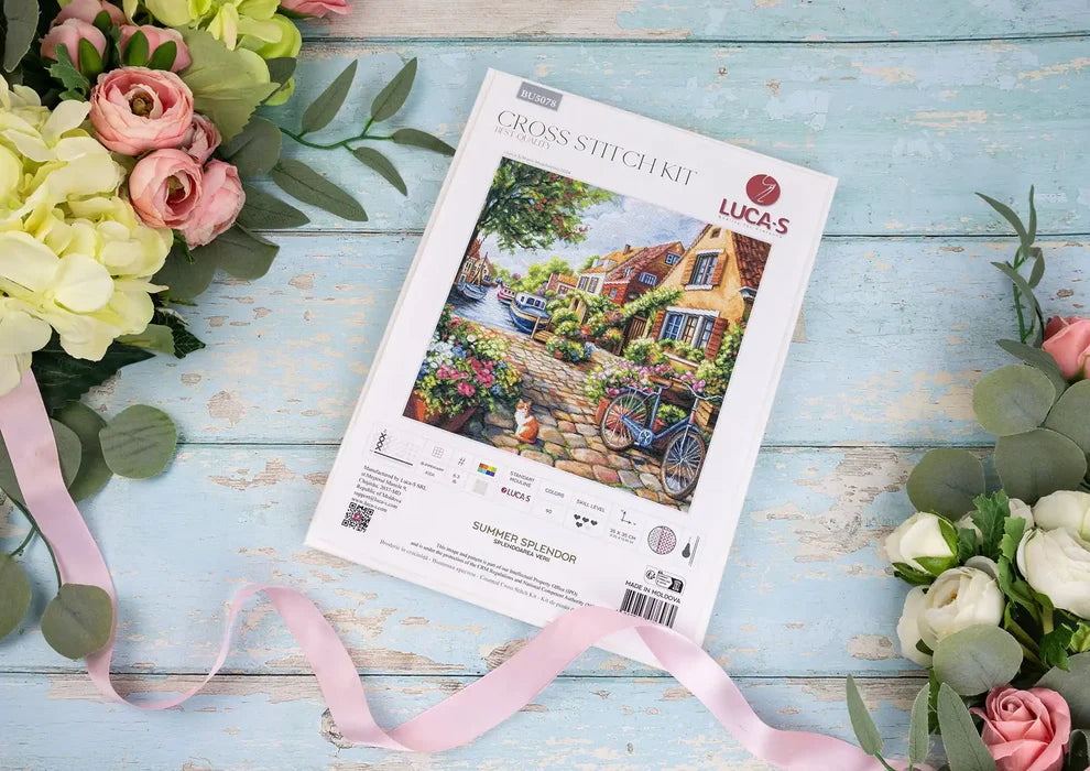 Lucas cross-stitch kit on a wooden surface with flowers and ribbons