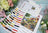 Cross stitch kit with color chart and floral decorations on a wooden surface
