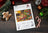 Lucas cross-stitch kit packaging with Christmas-themed decorations on a wooden surface