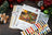 Cross stitch kit with colorful threads and Christmas-themed design on a wooden surface.