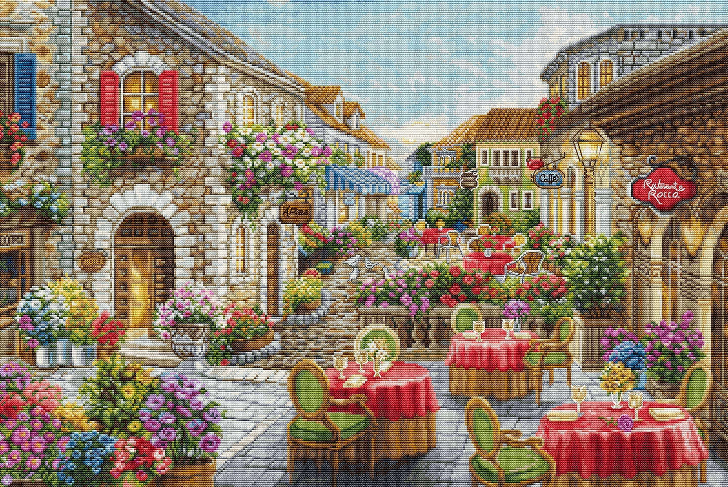 Stitched scene of a quaint European street with shops, tables, and chairs.