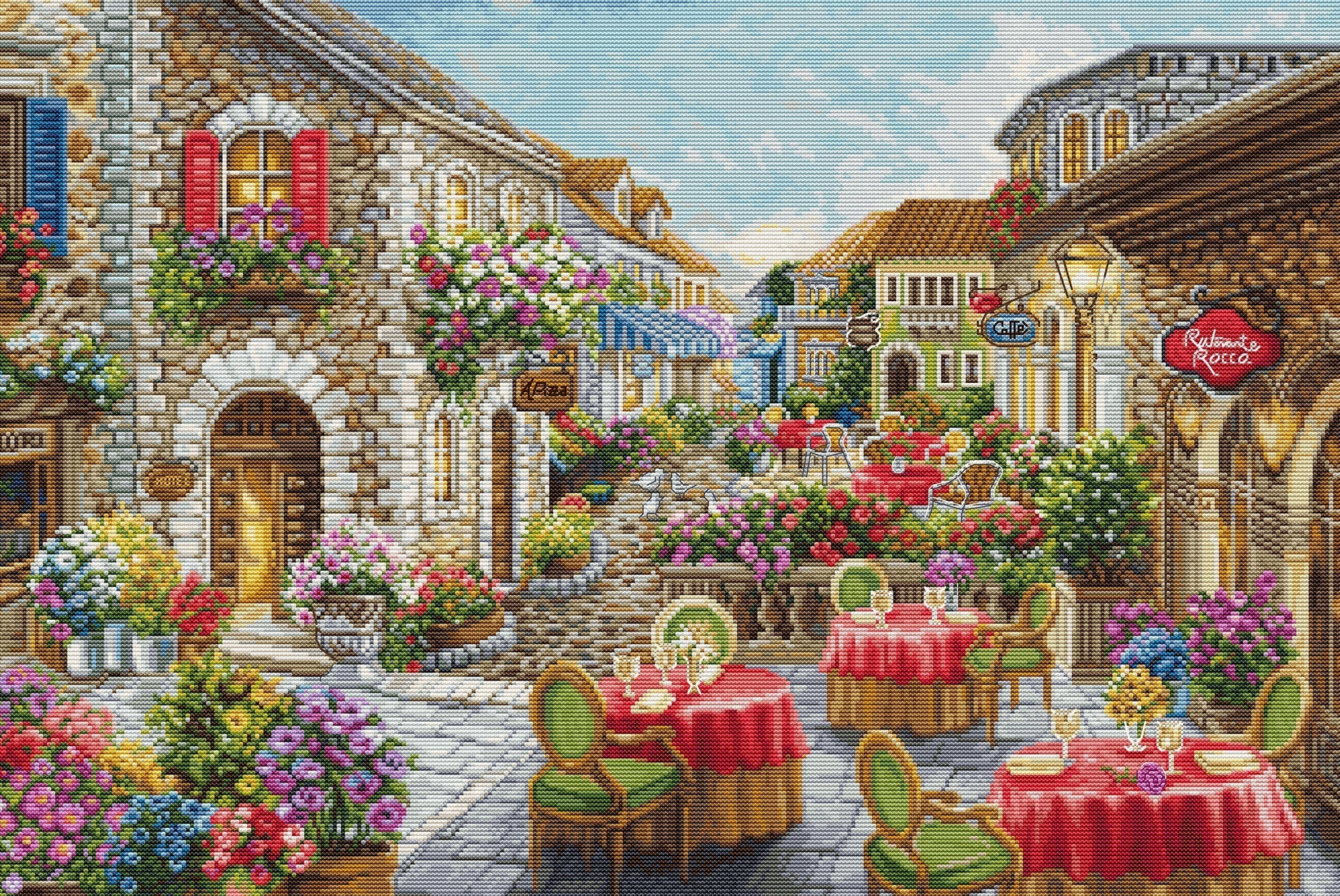 Stitched scene of a quaint European street with shops, tables, and chairs.