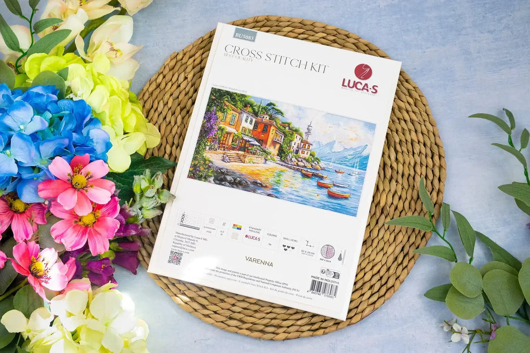 Cross stitch kit by Luca's on a woven mat with flowers around