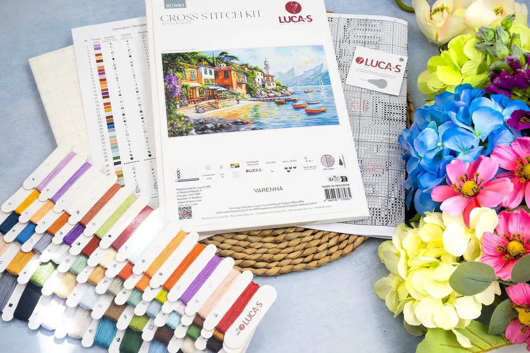 Cross stitch kit with thread set and colorful flowers on a blue surface