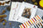 Lucas cross-stitch kit with pattern sheet, color chart, and materials on a textured surface.