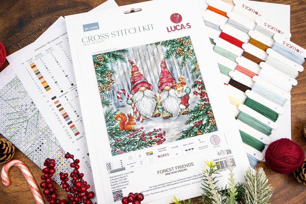 Lucas cross-stitch kit with gnomes in a forest design on a wooden surface.