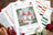 Lucas cross-stitch kit with gnomes in a forest design on a wooden surface.