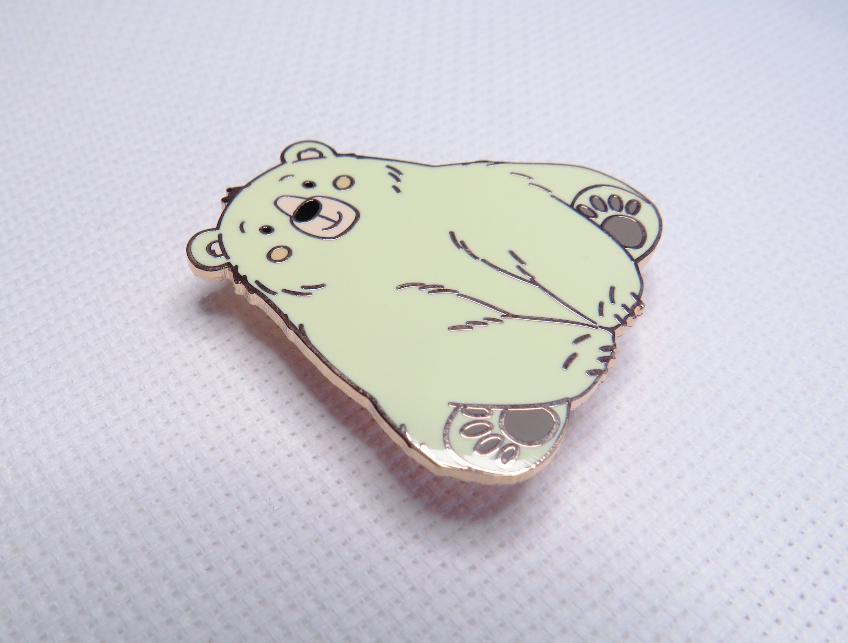 Green bear-shaped pin on a light gray background