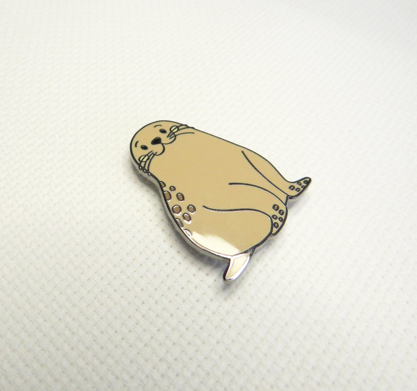 Beige seal-shaped Needleminder on a white background