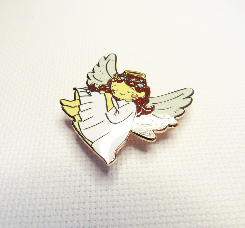 Angel-shaped needleminder on a textured white background