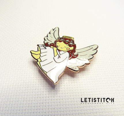 angel shaped needle minder on white canvas
