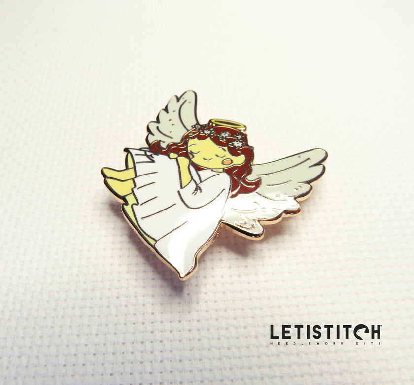 angel shaped needle minder on white canvas