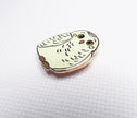 Owl-shaped pin on a white backgrounds