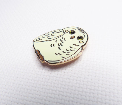 Owl-shaped pin on a white backgrounds