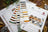 Cross-stitch kit with owl design and color swatch on a wooden surface.