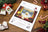 Lucas cross-stitch kit packaging on a wooden surface with Christmas decorations.