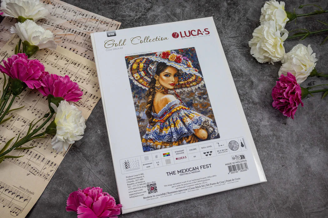 Lucas Gold Collection cross-stitch kit for 'The Mexican Fest' on a gray surface with flowers and music sheets.