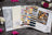 Color swatches and cross-stitch pattern book on a dark surface with flowers around
