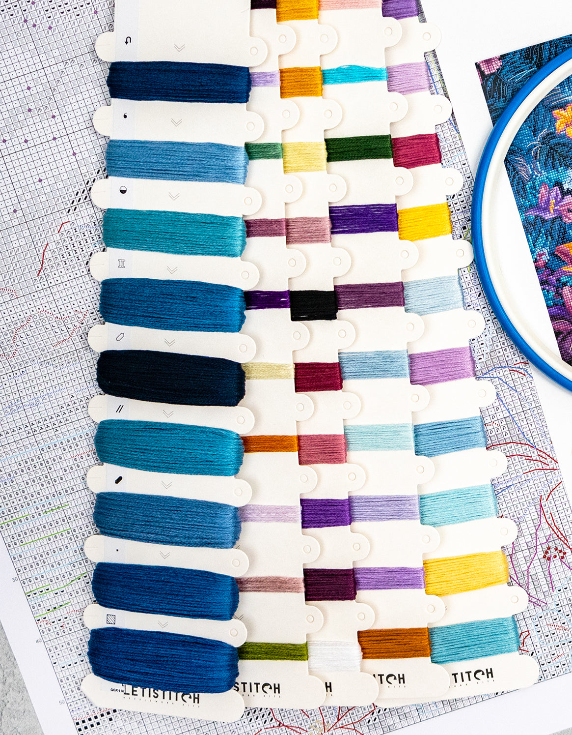 Color swatch card with various embroidery threads on a table with a patterned surface.