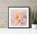 Framed artwork of a pink flower on a wooden wall with a plant.