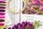 Embroidery hoop, fabric swatches, and floral elements on a table with a colorful embroidery design.