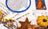 Embroidery hoop, fabric with pattern, color chart, and decorative items on a white surface