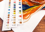 Color swatches and embroidery thread on a wooden surface