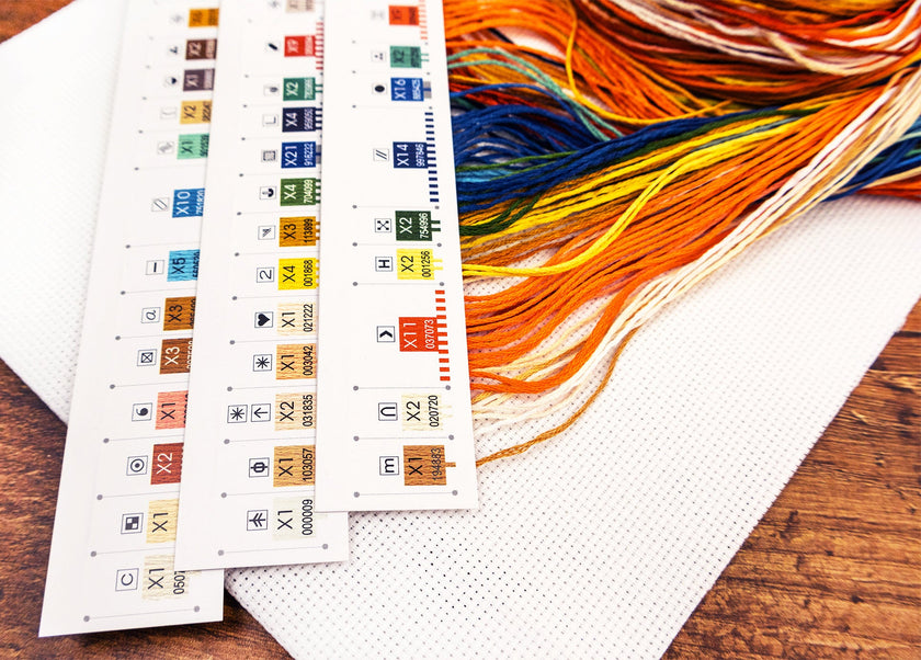 Color swatches and embroidery thread on a wooden surface
