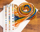 Color swatch book with yarn on a wooden surface