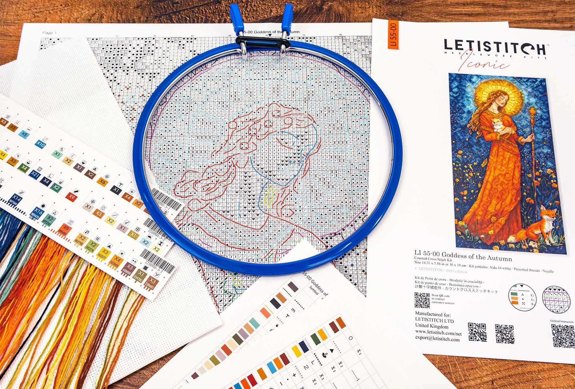 Embroidery hoop with cross-stitched design on a table with Letistitch embroidery kit and color swatches.