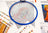 Embroidery hoop with cross-stitched design on a table with fabric and color swatches.
