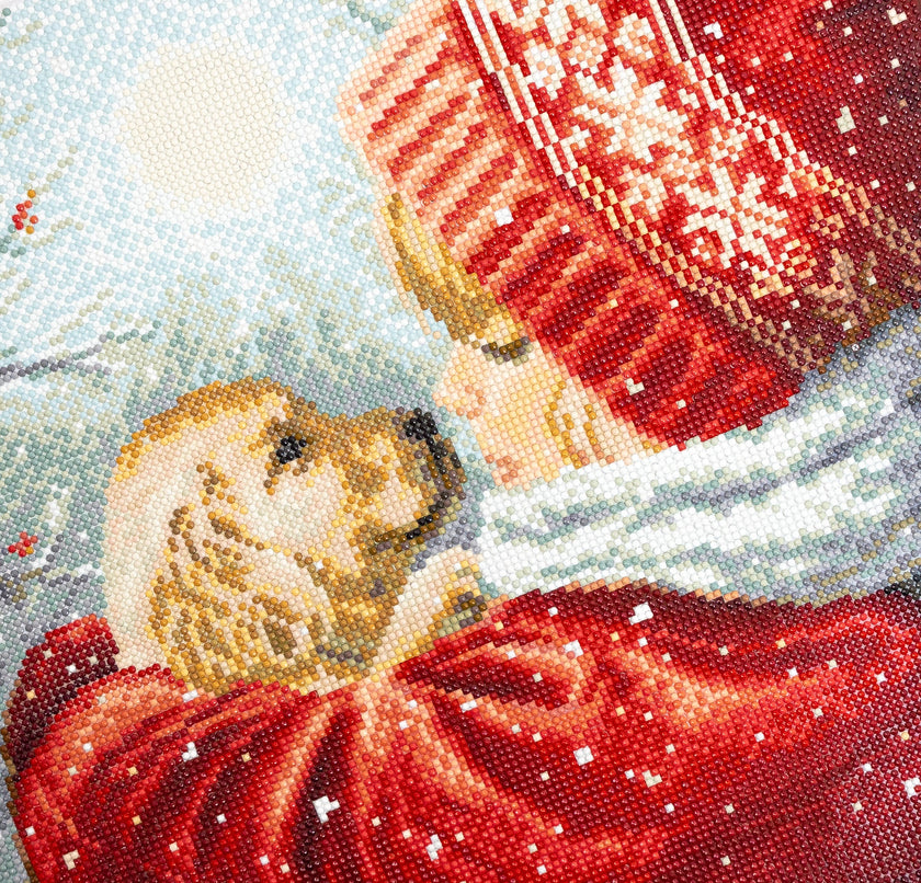 Close-up of a beaded artwork depicting a dog in a red coat with a snow-covered landscape.