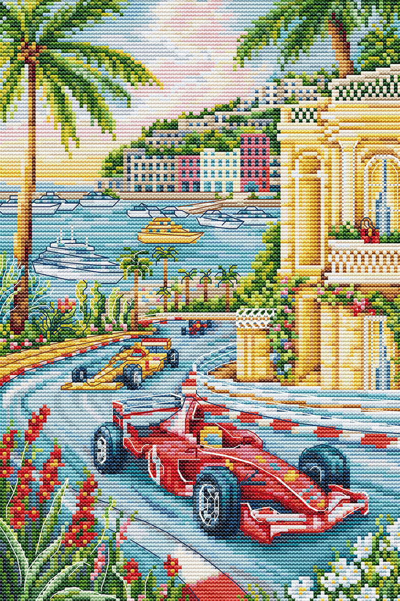 A colorful needlepoint canvas design depicting a Monaco-style coastal race scene with red and yellow Formula 1 cars on a winding track, palm trees, buildings, boats, and a pastel sky.