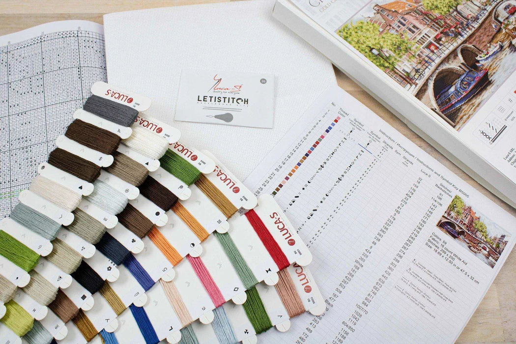 Color swatch book with embroidery thread samples on a table with a pattern book.