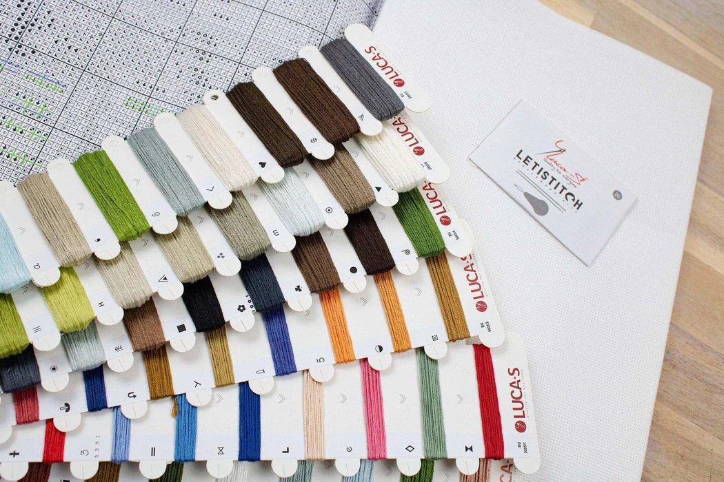 Color swatch card with thread samples on a wooden surface