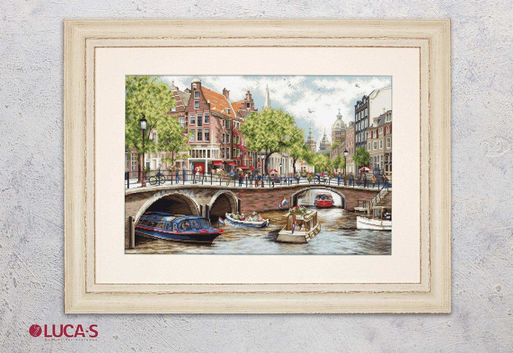 Framed artwork of a canal scene with boats and buildings, featuring the brand 'Lucas'.