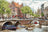 Dutch canal scene with boats, bridges, and traditional buildings.
