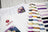 Color swatches and cross-stitch pattern on a wooden surface with Lucas brand visible.