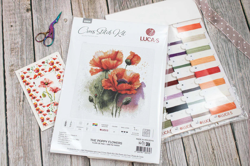 Cross stitch kit with poppy flowers design on a wooden surface