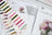 Set of embroidery thread spools and a cross stitch manual on a wooden surface